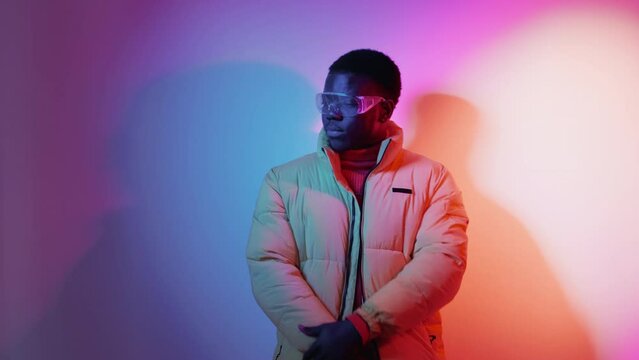 Neon fashion model. Stylish man. Urban style. Handsome cool fashionable guy posing in vivid glowing light on gradient free space background.