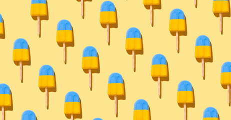 Trendy sunlight summer pattern made with blue-yellow ice cream on bright light yellow background. Minimal summer concept.