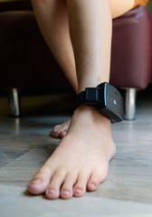 Prisoner is attached to an electronic monitoring on ankle - obrazy, fototapety, plakaty