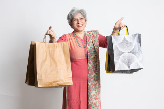 Happy excited indian senior mature woman holding shopping bags
