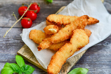 
 Crispy  deep Fried home made    Chicken strips Breaded  with  almond flour chicken  breast fillets  with chilly peppers and fresh   basil on wooden rustic background. Ketogenic diet food