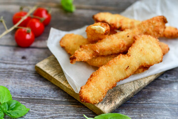 
 Crispy  deep Fried home made    Chicken strips Breaded  with  almond flour chicken  breast fillets  with chilly peppers and fresh   basil on wooden rustic background. Ketogenic diet food