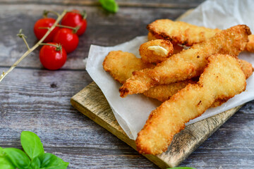 
 Crispy  deep Fried home made    Chicken strips Breaded  with  almond flour chicken  breast fillets  with chilly peppers and fresh   basil on wooden rustic background. Ketogenic diet food