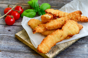
 Crispy  deep Fried home made    Chicken strips Breaded  with  almond flour chicken  breast fillets  with chilly peppers and fresh   basil on wooden rustic background. Ketogenic diet food