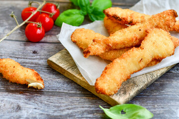 
 Crispy  deep Fried home made    Chicken strips Breaded  with  almond flour chicken  breast fillets  with chilly peppers and fresh   basil on wooden rustic background. Ketogenic diet food