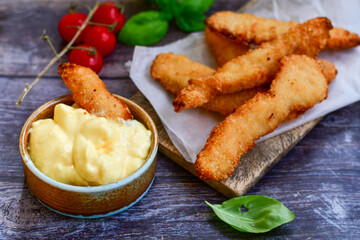 
 Crispy  deep Fried home made    Chicken strips Breaded  with  almond flour chicken  breast fillets  with chilly peppers and fresh   basil on wooden rustic background. Ketogenic diet food