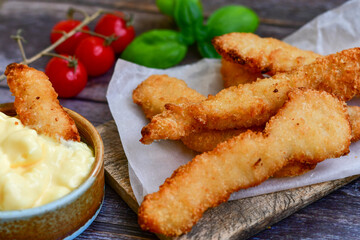 
 Crispy  deep Fried home made    Chicken strips Breaded  with  almond flour chicken  breast fillets  with chilly peppers and fresh   basil on wooden rustic background. Ketogenic diet food