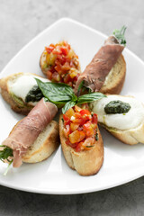 mixed crostini appetizers with parma ham, bruschetta and mozarella