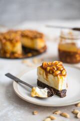homemade cheesecake with peanuts and caramel on a light background