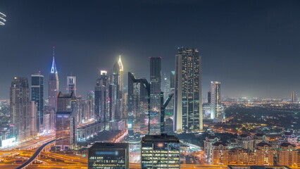 Panorama of Dubai Financial Center district with tall skyscrapers illuminated at night timelapse.