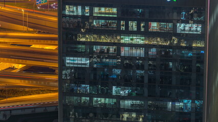 Outside view of windows in offices of a high class building at night timelapse