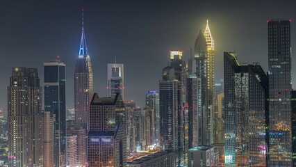 Dubai Financial Center district with tall skyscrapers illuminated at night timelapse.