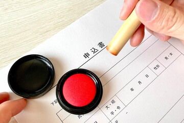 申込書に判を押す手元アップ