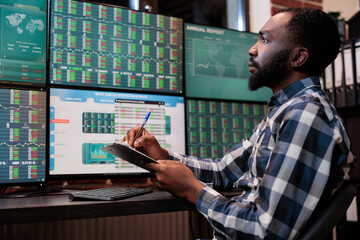 Business company professional employee with clipboard looking at real time financial data charts....