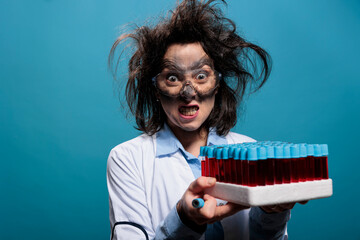 Crazy and angry chemist with laboratory glassware tray having test tubes filled with red liquid...