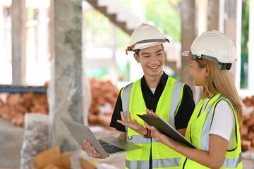 Team of civil engineer wearing uniform and safety helmet inspecting industrial building construction site