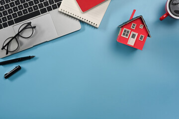 Laptop computer, glasses, notepad and house model on lea background. Real estate investors, insurance and maintenance concept - obrazy, fototapety, plakaty