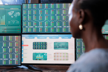 Close up shot of forex stock market investor sitting in front of multi display workstation. Business company financial advisor reviewing hedge fund value growth while analyzing real time data.