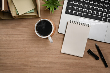 Laptop computer, blank notepad, pen and coffee cup on wooden tale. Flat lay, Top view