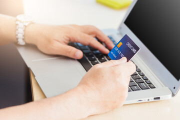 Closeup Asian senior adult man holding credit card and using technology on laptop computer, Online shopping payment with a customer network connection via an Omnichannel system