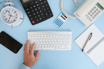 Office desk table with smartphone, laptop computer, cup of coffee and supplies. Top view with copy space, flat lay. Bank notebook with pen are on top of office desk table with computer tools.