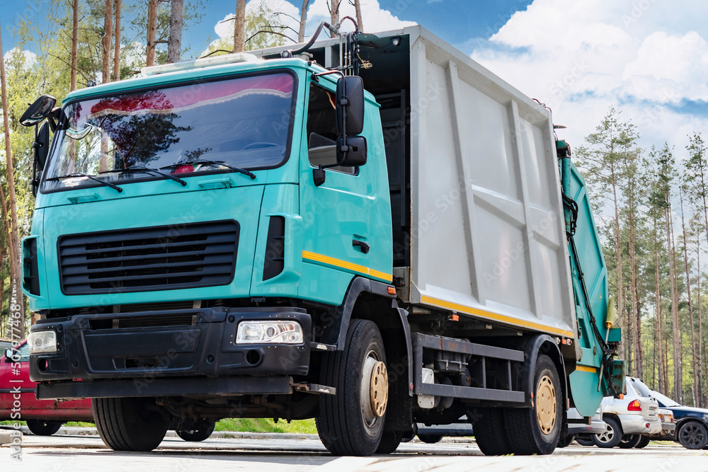 Leinwandbilder A garbage truck picks up garbage in a residential area. Loading mussar in containers into the car. Separate collection and disposal of garbage. Garbage collection vehicle.