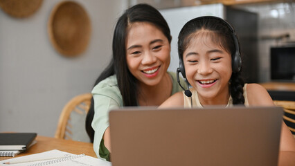 Pretty cute Asian girl enjoy watching funny video or learning an online class via laptop
