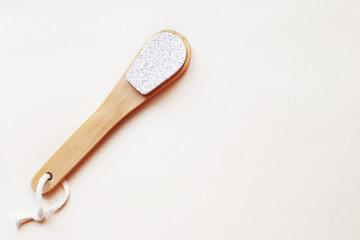 eco friendly foot pumice stone on beige background with copy space. woman legs care concept