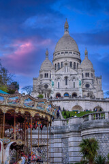 Fototapeta premium Purple twilight above the Sacré-Coeur Basilica on the top of the Montmartre hill in Paris, France with a carousel in the foreground.