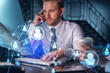 Businessman and businesswoman in formal wear working together looking for new employees to hire for international business consulting. HR, social media icons over modern panoramic office background