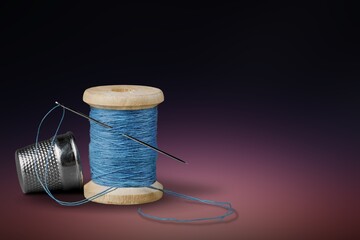 A sewing thread with needle on dark background,