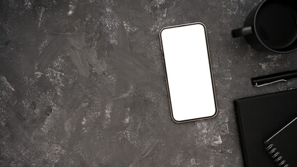 Top view of a smartphone or cellphone white screen mockup on loft grey background.