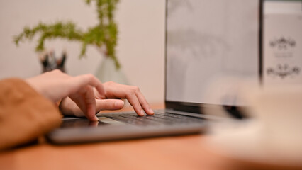 Female typing on keyboard, searching something on the website via laptop computer.