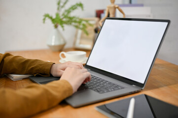 Close-up female freelancer using laptop computer, typing on keyboard, doing her online work