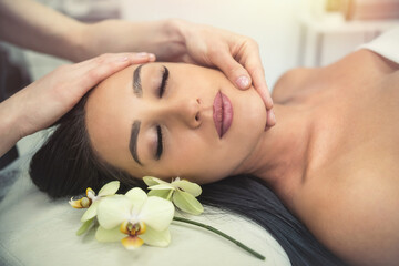 Obraz na płótnie Canvas close up of beautician hands doing relaxing rejuvenating massage female client at spa salon
