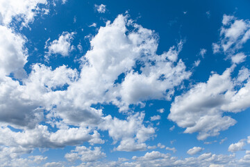 White cumulus clouds on bright blue sky