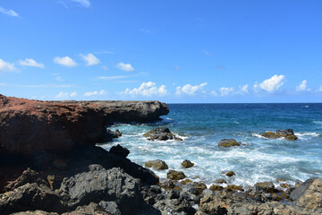 Fototapeta na wymiar Black Lava Rock with Waves Coming Ashore in Aruba