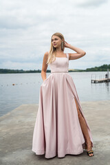 Fototapeta na wymiar fantasy charming woman in elegant ping evening dress relaxing near lake