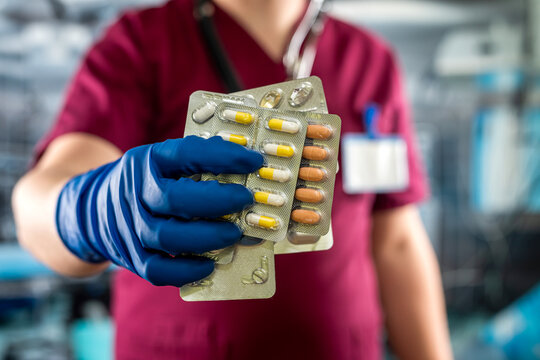 Male Doctor Holding  Pack Of Different Tablet Pills In Hospital Room