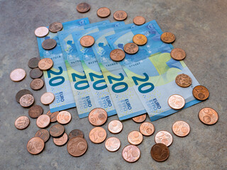 Twenty euro banknotes and euro cent coins on the ground