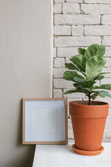 Blank photo frame mock up, potted plant in modern interior.