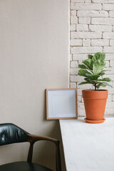 Modern minimalistic interior with photo frame mock up, potted plant.