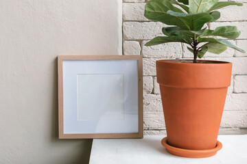 Blank poster frame mock up, potted plant in the interior. Template.