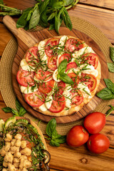 Margarita Pizza with tomatoes and species in a wood table