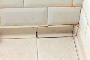 Cracked seam between tiles on the bathroom floor