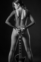 Sexy woman in fishnets holding guitar