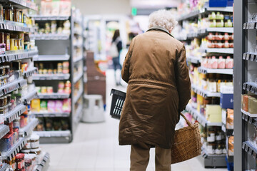 Rentnerin beim Lebensmittel einkaufen in einem Supermarkt während der Inflation - obrazy, fototapety, plakaty