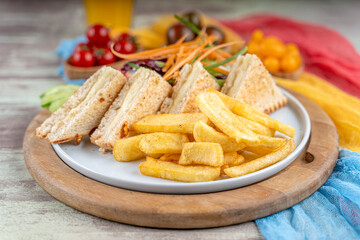 Traditional sandwich made from slices of toasted bread, cheese served with orange juise ,fried patatoe, salads and different colors of tomatoes.