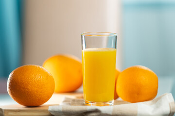 Orange juice is pouring into the glass. Healthy vegan food. Vitamins food. Ripe oranges.