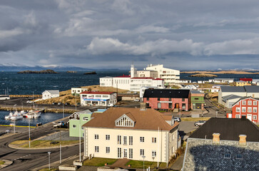 Obraz premium Stykkisholmur, Iceland, May 3, 2022: evening sun illuminates houses, the hospital and other buildings around the harbour